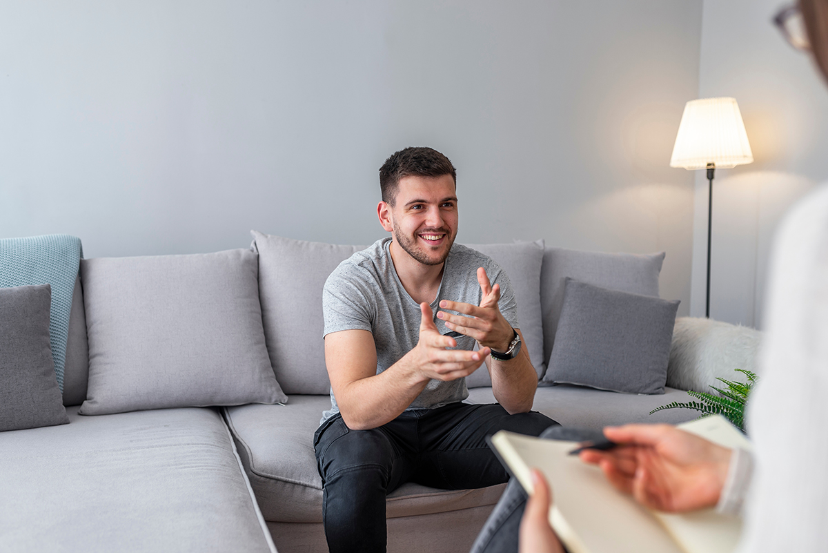 Psychologist talking with happy man in the office