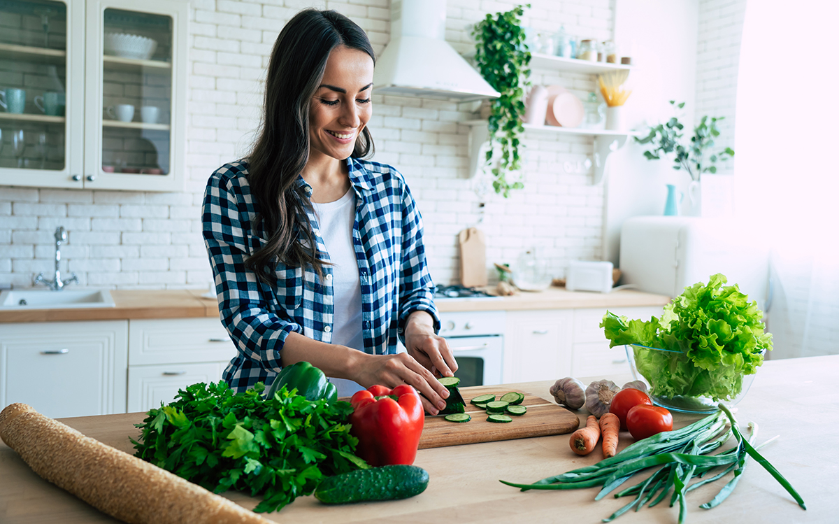 woman is preparing vegetable salad in the kitchen